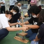 採火式で懸命に火をおこす児童生徒や保護者たち＝和田山特別支援学校