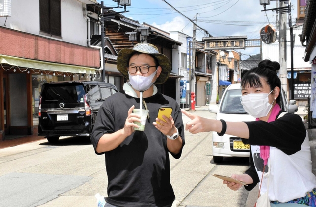 街歩きの試演会で参加者に説明する高野桂子さん（右）＝豊岡市出石町田結庄