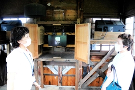 観光ガイドの案内で、辰鼓楼の内部を見学する来場者＝豊岡市出石町内町