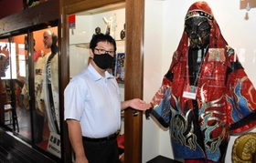 店内に飾られる「グレート・ムタ」の衣装を説明する森山順一郎社長＝武藤道場豊岡店