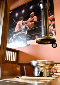 テーブル横に掲示された試合のパネル＝武藤道場豊岡店