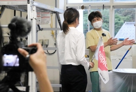 撮影で酒蔵を案内する酒造会社「田治米」の田治米博貴社長（右）＝朝来市山東町矢名瀬町