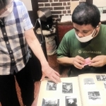 聞き取り取材をする脚本指導・演出担当のごまのはえさん＝ヒグラシ珈琲（毛帽子事務所提供）