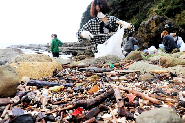 発泡スチロールの破片など漂着した海洋ごみを拾い集める参加者＝猫崎半島