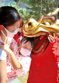 健やかな成長を願い、子どもの頭をかむ麒麟獅子＝新温泉町和田