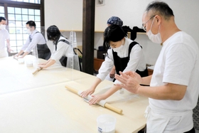 出石皿そば協同組合の組合員たちからそば打ちを教わる生徒たち＝豊岡市出石町小人