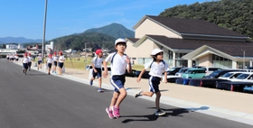新文化会館「やぶ市民交流広場」の周辺を走る八鹿小の児童たち＝養父市八鹿町八鹿
