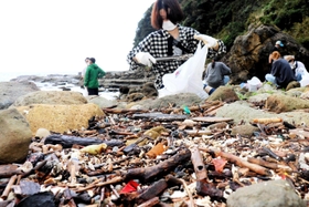 発泡スチロールの破片など漂着した海洋ごみを拾い集める参加者＝猫崎半島