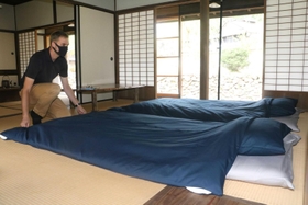 自ら清掃し、布団のセッティングをするレハンさん＝朝来市生野町口銀谷
