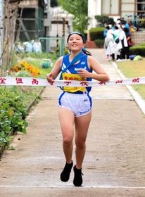 笑顔でゴールする豊岡総合のアンカー林奈緒選手＝豊岡市出石町口小野