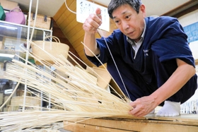 柳行李を編む寺内卓己さん＝豊岡市出石町魚屋