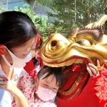 健やかな成長を願い、子どもの頭をかむ麒麟獅子＝新温泉町和田