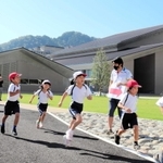 新文化会館「やぶ市民交流広場」の周辺を走る八鹿小の児童たち＝養父市八鹿町八鹿
