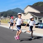 新文化会館「やぶ市民交流広場」の周辺を走る八鹿小の児童たち＝養父市八鹿町八鹿
