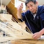 柳行李を編む寺内卓己さん＝豊岡市出石町魚屋