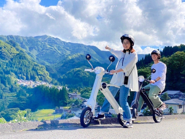 電動バイクに乗って小代地域の豊かな自然を満喫できる周遊サービス「小代ぷちたび」＝今年９月、香美町小代区貫田（香美町小代観光協会提供）