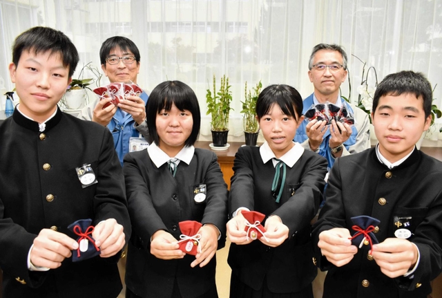 お守りを手にする生徒と大日本土木の社員＝豊岡南中