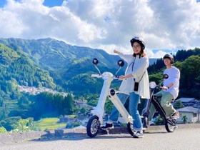 電動バイクに乗って小代地域の豊かな自然を満喫できる周遊サービス「小代ぷちたび」＝今年９月、香美町小代区貫田（香美町小代観光協会提供）