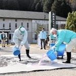 敷地の入口に消毒液をまく職員ら＝県立コウノトリの郷公園