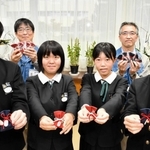 お守りを手にする生徒と大日本土木の社員＝豊岡南中