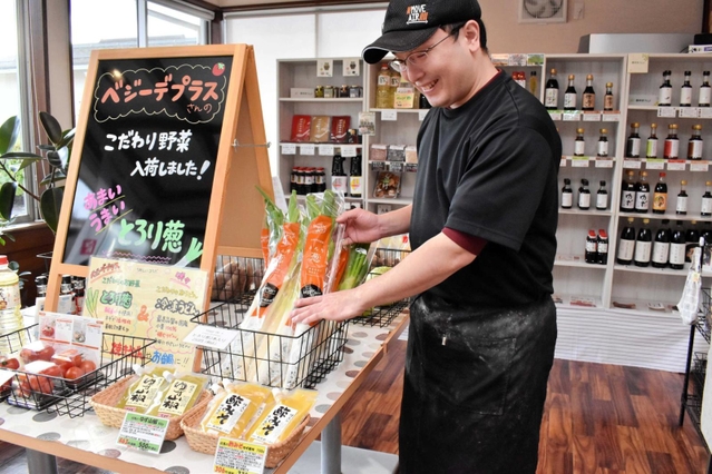 地元企業の調味料や野菜などを販売する「咲々マーケット」をオープンさせた山田雅さん＝豊岡市福田