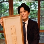 野口雨情がしたためた短冊を手にする西村総一郎社長＝西村屋