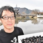 円山川で採れたシジミを手にする永沢賢作さん＝豊岡市内