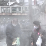 湯村温泉の泉源「荒湯」近くで温泉卵づくりを体験する観光客＝新温泉町湯、湯村温泉