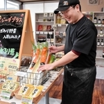 地元企業の調味料や野菜などを販売する「咲々マーケット」をオープンさせた山田雅さん＝豊岡市福田