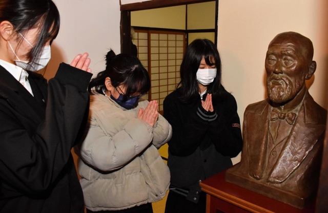 加藤弘之の胸像に向かって合格を祈願する生徒たち＝豊岡市出石町下谷