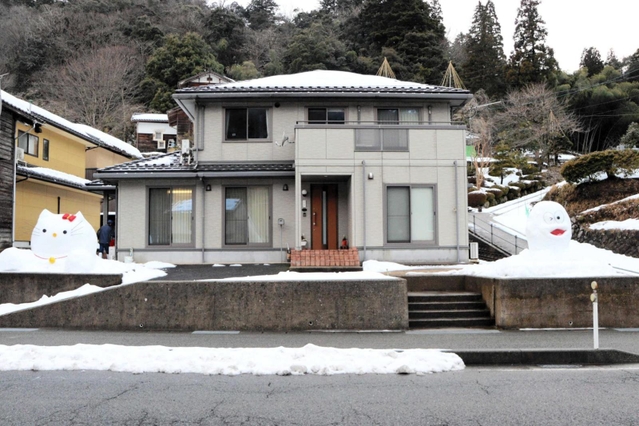 道路を向いた大きなキャラクターの雪像＝豊岡市竹野町