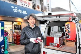 ＪＲ八鹿駅近くにある田中酒店で焼き芋を販売する田中正司さん＝養父市八鹿町八鹿