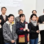 但馬空港ターミナルの桐山徹郎社長（前列右端）から賞状を受け取る最優秀賞受賞チームのメンバー＝芸術文化観光専門職大学