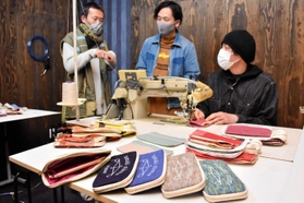 播州織の生地で作る財布について話し合う（左から）藤本隆太さんと下村浩平さん、奥田喜志人さん＝豊岡市但東町赤花