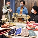 播州織の生地で作る財布について話し合う（左から）藤本隆太さんと下村浩平さん、奥田喜志人さん＝豊岡市但東町赤花