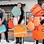 かばんをたくさん持っているように見えるパネル＝豊岡市中央町
