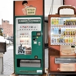 カバンをモチーフにした自販機（右）と手提げかばんが出てくる「カバンの自販機」、モニュメント＝豊岡市中央町
