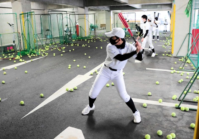 雨天のため、校内の地下駐車場で打撃練習。通常のバットと重いマスコットバットを使い分けながら、テニスボールを打ち込む＝八鹿青渓中