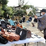 使い古したかばんが持ち込まれ、供養が行われた＝豊岡市小田井町