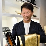 金箔を施したヘビ革を内側に使用した財布を手にするオーナーの土生田直樹さん＝豊岡市中央町