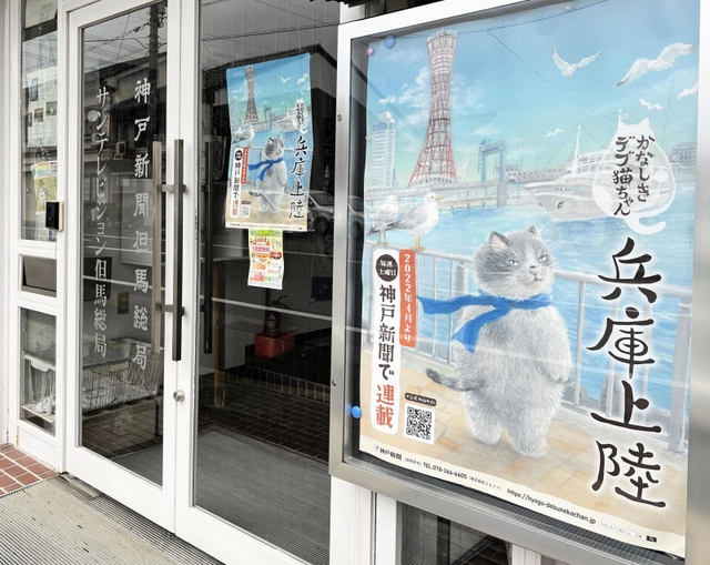 主人公「マル」が描かれたポスターが掲示された神戸新聞但馬総局＝豊岡市寿町