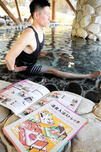 温泉に漬かりながら行うストレッチのノウハウをまとめたパンフレットを手掛けた阿瀬宏太さん＝新温泉町湯