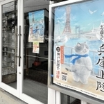 主人公「マル」が描かれたポスターが掲示された神戸新聞但馬総局＝豊岡市寿町