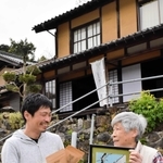 改修した築約９０年の民家で鹿肉のペットフード商品の販売を始める白井壮さん（左）と記念の切り絵を作成した剪画家の坂田陽一さん＝豊岡市日高町八代