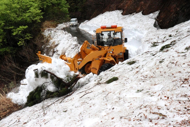 斜面の雪や落石などを取り除きながら進む除雪車＝上山高原