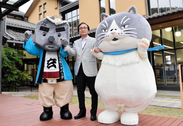 豊岡市立図書館のいこいの広場で記念撮影をする（左から）玄さんと西上均副市長、マル＝豊岡市京町