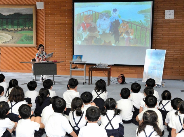 子どもたちに「かなしきデブ猫ちゃん」を読み聞かせる河合美智子さん＝豊岡小学校
