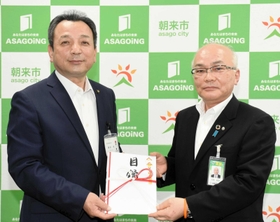 藤岡市長（左）に目録を手渡した但陽信用金庫の大西専務理事＝朝来市役所
