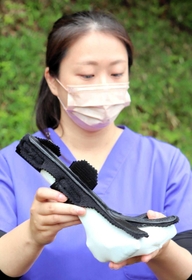 試作を重ねた装具を持つ川上紀子さん＝県立コウノトリの郷公園