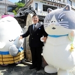 湯村温泉の観光スポット「荒湯」で朝野泰昌・湯村温泉観光協会長（中央）、ゆーたんと記念撮影するマル（右）＝新温泉町湯